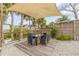 Outdoor dining area with shade sail, overlooking the water at 130 Indian Creek Rd, Oak Hill, FL 32759