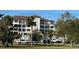 Condo building exterior with lush landscaping and parking at 200 S Riverside Dr # 2010, New Smyrna Beach, FL 32168