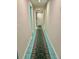 Long hallway with teal tile flooring and patterned area rug at 200 S Riverside Dr # 2010, New Smyrna Beach, FL 32168
