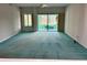 Spacious living room with teal carpet and sliding glass doors at 200 S Riverside Dr # 2010, New Smyrna Beach, FL 32168