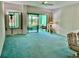 Living room with teal carpet, sliding doors, and balcony access at 200 S Riverside Dr # 2010, New Smyrna Beach, FL 32168