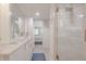 Bathroom with white vanity, marble countertop, walk-in shower, and view to the bedroom at 2401 S Atlantic Ave # C206, New Smyrna Beach, FL 32169