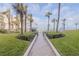 Community pool area with palm trees and a walkway to the beach at 2401 S Atlantic Ave # C206, New Smyrna Beach, FL 32169