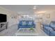 Living area with blue couches, a white kitchen, and light wood-look flooring at 2401 S Atlantic Ave # C206, New Smyrna Beach, FL 32169