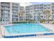 Community pool with surrounding lounge chairs at 2401 S Atlantic Ave # C206, New Smyrna Beach, FL 32169