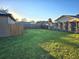 Open grassy backyard with a wooden fence at 2729 Pine Tree Dr, Edgewater, FL 32141