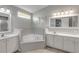 Bathroom with corner tub, double vanity, and grey tile at 2853 Turnbull Estates Dr, New Smyrna Beach, FL 32168