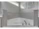 Bathroom with corner tub and grey tile at 2853 Turnbull Estates Dr, New Smyrna Beach, FL 32168