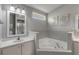 Bathroom with corner tub, double vanity, and grey tile at 2853 Turnbull Estates Dr, New Smyrna Beach, FL 32168