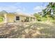 Rear view of a yellow single-story house with a screened porch and lawn at 2853 Turnbull Estates Dr, New Smyrna Beach, FL 32168