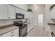 Kitchen with white cabinets, black appliances, and gray countertops at 2853 Turnbull Estates Dr, New Smyrna Beach, FL 32168
