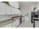 Modern kitchen with white cabinets, black appliances and grey countertops at 2853 Turnbull Estates Dr, New Smyrna Beach, FL 32168