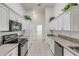 White kitchen with gray countertops and stainless steel appliances at 2853 Turnbull Estates Dr, New Smyrna Beach, FL 32168