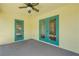 Enclosed porch with two teal doors and a ceiling fan at 2853 Turnbull Estates Dr, New Smyrna Beach, FL 32168