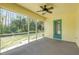 Bright screened porch with ceiling fan, access to backyard, and teal door at 2853 Turnbull Estates Dr, New Smyrna Beach, FL 32168