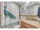Clean bathroom with a peacock shower curtain and updated vanity at 3501 S Atlantic Ave # 407, New Smyrna Beach, FL 32169