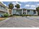 Two-story building with parking lot and palm trees at 3509 S Atlantic Ave # 108 & 109, New Smyrna Beach, FL 32169