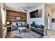 Living room with wood accent wall, gray sofa, and large TV at 3509 S Atlantic Ave # 108 & 109, New Smyrna Beach, FL 32169