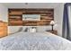 King-size bed in bright bedroom with wood accent wall at 3509 S Atlantic Ave # 108 & 109, New Smyrna Beach, FL 32169
