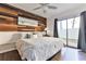 King-size bed, wood accent wall, and sliding glass door to backyard at 3509 S Atlantic Ave # 108 & 109, New Smyrna Beach, FL 32169