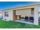 Covered patio with blue wicker chairs and retractable shades at 355 Caryota Ct, New Smyrna Beach, FL 32168