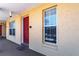 Red front door entrance to condo unit with window and number at 3801 S Atlantic Ave # Ut104, New Smyrna Beach, FL 32169