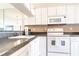 White kitchen with granite countertops and modern appliances at 3801 S Atlantic Ave # Ut104, New Smyrna Beach, FL 32169