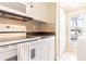 White kitchen with stove, microwave and cabinets at 3801 S Atlantic Ave # Ut104, New Smyrna Beach, FL 32169