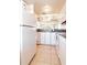 White kitchen with refrigerator and ample cabinet space at 3801 S Atlantic Ave # Ut104, New Smyrna Beach, FL 32169