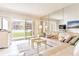 Living room with a beige leather sectional sofa, offering pool and partial ocean views at 3801 S Atlantic Ave # Ut104, New Smyrna Beach, FL 32169