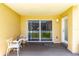 Small patio with sliding glass doors and white chairs at 3801 S Atlantic Ave # Ut104, New Smyrna Beach, FL 32169