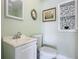 Small bathroom with white vanity, toilet, and pebble accent wall at 409 N Ridgewood Ave, Edgewater, FL 32132