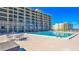 Community pool with surrounding patio furniture at 4139 Atlantic # A406, New Smyrna Beach, FL 32169