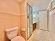 Clean bathroom with tiled walls and floors, toilet, and mirrored vanity at 4150 S Atlantic Ave # 103A, New Smyrna Beach, FL 32169