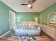 Light green bedroom with king bed, wood floors, and ceiling fan at 4150 S Atlantic Ave # 103A, New Smyrna Beach, FL 32169