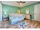 Bedroom with king-size bed, light green walls, and ceiling fan at 4150 S Atlantic Ave # 103A, New Smyrna Beach, FL 32169