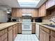 Efficient kitchen with white appliances and wood cabinetry at 4150 S Atlantic Ave # 103A, New Smyrna Beach, FL 32169