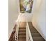 Indoor staircase with neutral carpeting and white railings at 4150 S Atlantic Ave # 103A, New Smyrna Beach, FL 32169