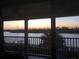 Serene sunset view from a screened balcony overlooking the water at 460 Bouchelle Dr # 305, New Smyrna Beach, FL 32169