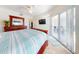 Bright bedroom with a king-size bed, dresser, and sliding glass doors leading to a balcony at 5300 S Atlantic Ave # 1-203, New Smyrna Beach, FL 32169