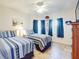 Bedroom with two twin beds, tile floor, and ceiling fan at 5300 S Atlantic Ave # 1-203, New Smyrna Beach, FL 32169
