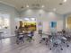 Community room with kitchenette and tables with chairs at 5300 S Atlantic Ave # 1-203, New Smyrna Beach, FL 32169
