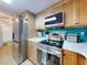 Kitchen with stainless steel appliances and teal tile backsplash at 5300 S Atlantic Ave # 1-203, New Smyrna Beach, FL 32169