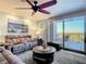 Living room with reclining sofas, ceiling fan, and balcony access at 5300 S Atlantic Ave # 17-506, New Smyrna Beach, FL 32169