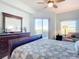Main bedroom with wood furniture and access to a private balcony at 5300 S Atlantic Ave # 17-506, New Smyrna Beach, FL 32169