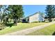 Side view of the house showcasing a screened patio and well-maintained lawn at 686 Middlebury Loop, New Smyrna Beach, FL 32168