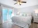 Inviting bedroom with a king-size bed, ceiling fan, and doors leading to a balcony at 742 Laurel Bay Cir, New Smyrna Beach, FL 32169