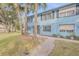 Light blue townhouses with a walkway and palm trees at 101 N Pine St # 7, New Smyrna Beach, FL 32169