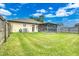Backyard with screened patio, grassy area, and wooden fence at 1331 Umbrella Tree Dr, Edgewater, FL 32132