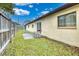 Side yard with patio, grassy area, and wooden fence at 1331 Umbrella Tree Dr, Edgewater, FL 32132